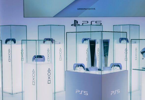 PlayStation 5 consoles and accessories on display in a sleek, futuristic showroom.